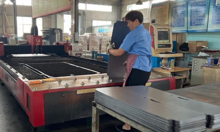 Worker Handling Laser-Cut Metal Sheets