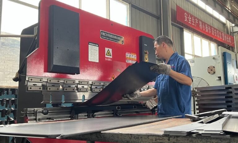 Worker Loading Metal Sheet into Bending Machine